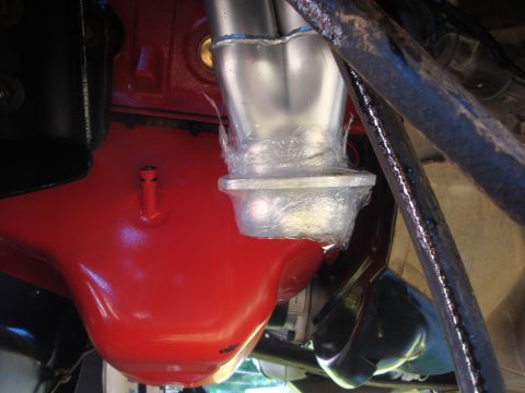 1989 Ford Bronco - Engine part and exhaust manifold detail, wrapped in plastic.
