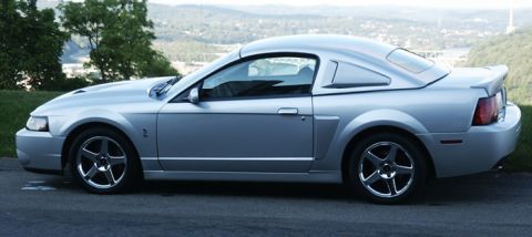 2007 Ford Mustang - Side view of a silver coupe parked outdoors with a scenic background.