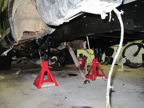 1979 Ford Bronco - Underbody view of a vehicle undergoing maintenance, supported by jack stands.