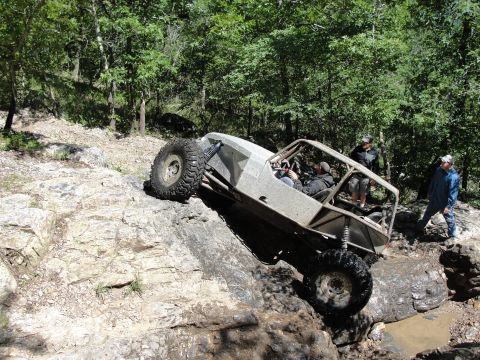 1967 Ford Mustang - A custom-built off-road buggy navigates a challenging rocky terrain with spectators nearby.