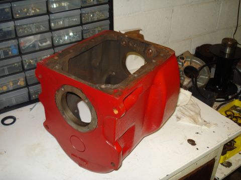 1991 Ford Bronco - A red metal casing, possibly a transmission or differential housing, is shown on a workbench.