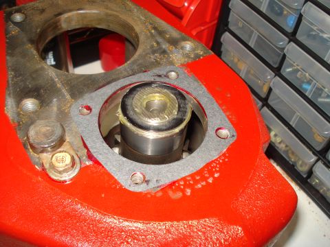 1991 Ford Bronco - A gasket is being installed on a red-painted metal component, likely part of a vehicle's drivetrain.