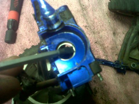 2011 Ford 427 - Close-up of a blue RC car suspension part being worked on with a hex wrench.