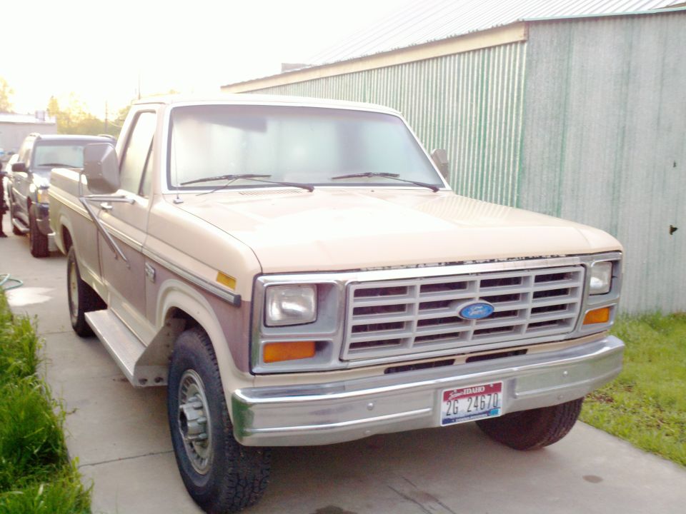 Tan 1980s Ford F-Series truck parked next to another vehicle, front view