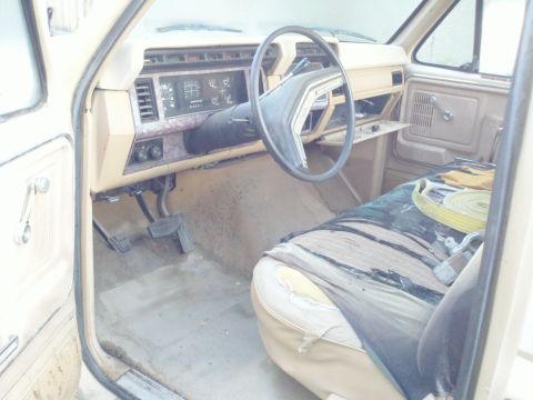 1985 Ford F-250 - The interior of this truck shows a worn seat and dashboard, suggesting an older model year.