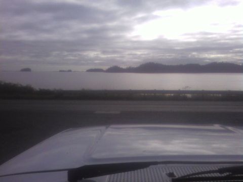 1989 Ford Bronco - The view from a vehicle's hood shows a calm body of water with islands in the distance under an overcast sky.