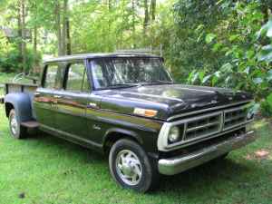 1995 Ford Bronco - This black pickup truck has a long body with two rows of doors and a truck bed.