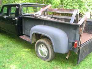 1995 Ford Bronco - A black pickup truck is seen from the rear three-quarter angle, parked on a grassy area.