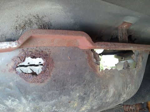 1989 Ford Bronco - Severe rust damage is visible on the vehicle's undercarriage, with large holes exposing internal parts.