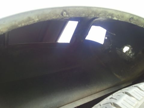 1989 Ford Bronco - This is a view inside the wheel well of a vehicle, showing some openings to the outside.
