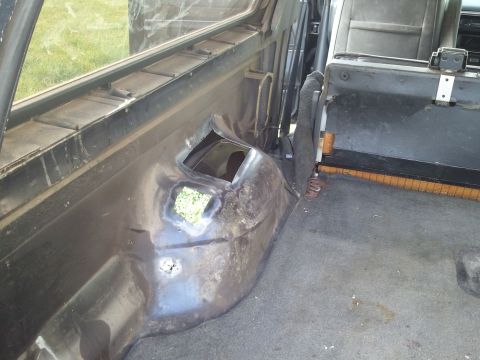 1989 Ford Bronco - The interior of an older SUV shows significant wear and tear around the rear wheel well.
