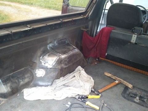 1989 Ford Bronco - Tools and a red towel are visible inside a vehicle, with evidence of metal repair on the floor.
