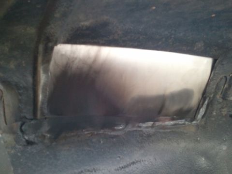 1989 Ford Bronco - Underside view of a vehicle's metal structure with a visible opening and some welding marks.