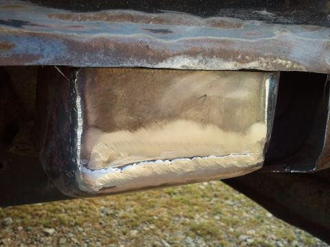 1989 Ford Bronco - Close-up of a metal repair on a vehicle frame, with visible welding and grinding.