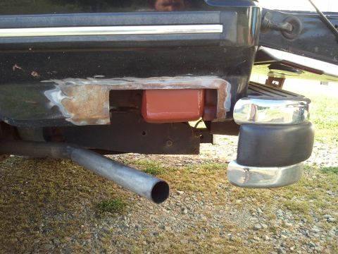 1989 Ford Bronco - Close-up of a vehicle's rear bumper showing rust damage and a section being prepped for repair.