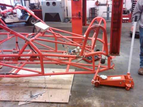 1995 Ford F-150 - A custom-built tube chassis is shown in a workshop setting, with tools and equipment visible in the background.