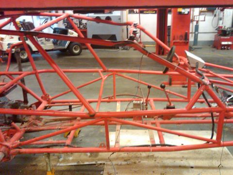 1995 Ford F-150 - A custom-built tube frame chassis is suspended on a lift, revealing its intricate internal structure.