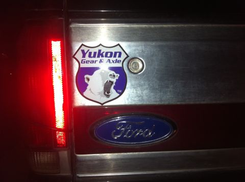1990 Ford Bronco - Close-up of a Ford tailgate a Yukon Gear & Axle sticker and the Ford logo.