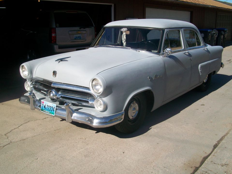 Gray sedan with a chrome grille and bumper, parked in a driveway
