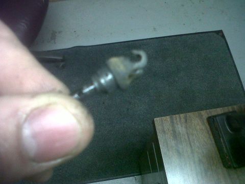 2011 Ford 427 - Close-up of a metal cable end with a hook, held by a finger.