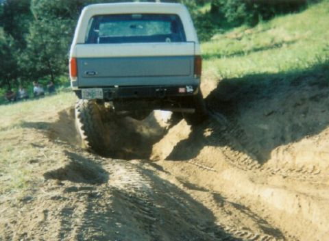1988 Ford Bronco - This 1988 Ford Bronco is navigating a challenging dirt path with its rear end visible.