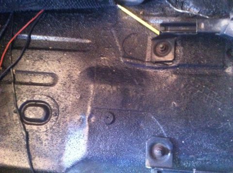 1990 Ford Bronco - Vehicle floor pan detail with visible wiring and mounting hardware.