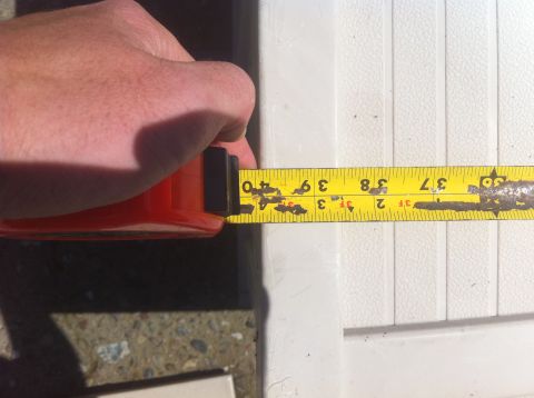 1990 Ford Bronco - A hand measures a white textured surface with a tape measure, indicating 39 inches.
