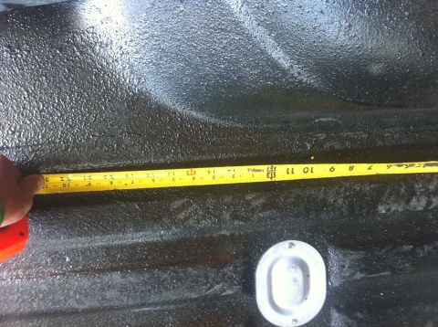 1990 Ford Bronco - A yellow measuring tape is used to measure the interior of a truck bed.