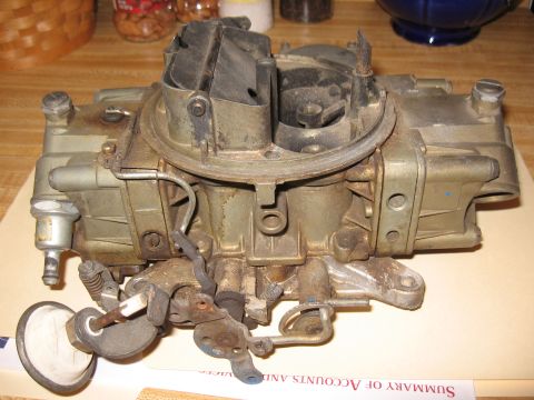 1968 Shelby GT500 - A used Holley carburetor is shown on a table, with visible wear and dust.