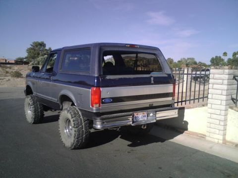 1995 Ford Bronco - This lifted 1995 Ford Bronco features a two-tone blue and silver paint scheme and aggressive off-road tires.