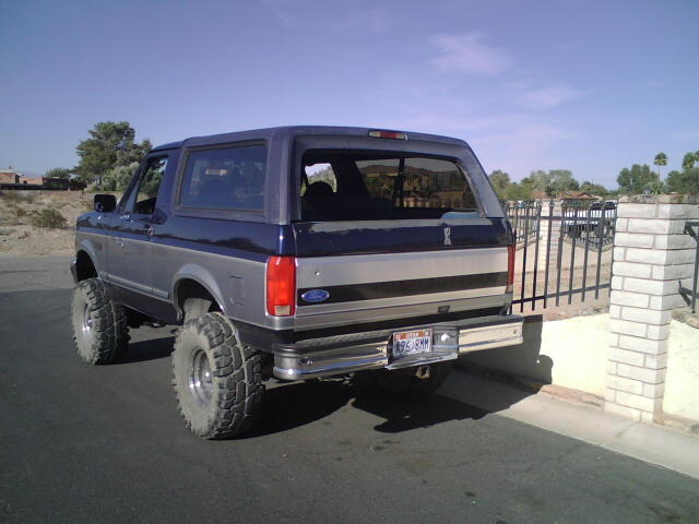 Rear view of blue and silver 1995 Ford Bronco with large tires