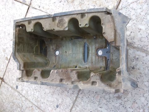 1998 Ford Crown Victoria - Cast metal engine intake manifold part with visible internal runners and mounting points.