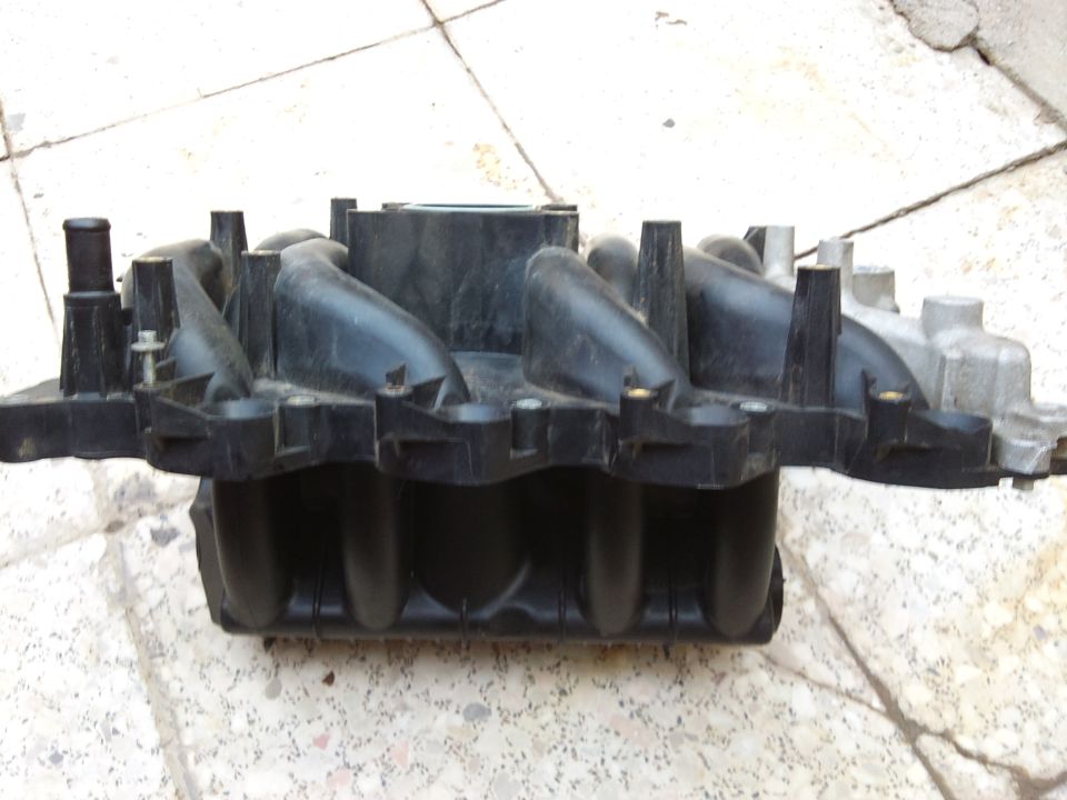 Plastic intake manifold with silver metal components attached