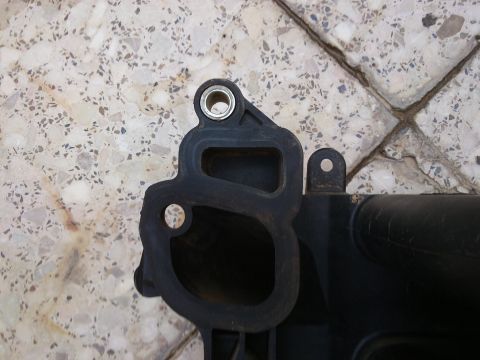 1998 Ford Crown Victoria - A black plastic automotive part, likely an intake manifold, is shown against a tiled background. The 'SUPERMOTORS' watermark is visible.