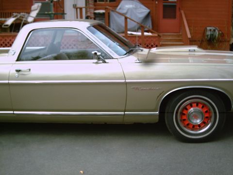 1969 Ford Ranchero - A gold 1969 Ford Ranchero is parked in front of a house with a deck and grill.