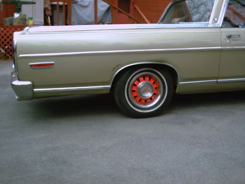 1969 Ford Ranchero - A 1969 Ford Ranchero is seen from the side, distinctive red wheel covers.