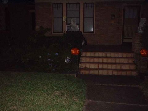 1996 Ford Taurus - A house entrance decorated for Halloween with lit pumpkins, one reading 'VILE!'.