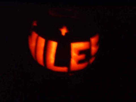 1996 Ford Taurus - A carved pumpkin glows with light, displaying the word 'MILE' in bold letters.