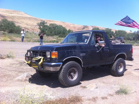 1990 Ford Bronco - This 1990 Ford Bronco is seen off-road with an American flag mounted on the back.