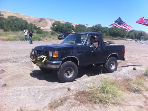 1990 Ford Bronco - This 1990 Ford Bronco is captured in a three-quarter front view while navigating an off-road course.