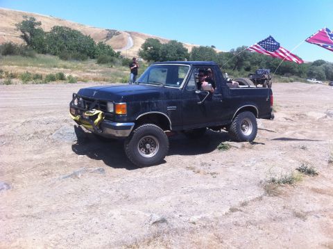 1990 Ford Bronco - This black Ford Bronco is equipped with a bull bar and yellow tow strap, ready for off-road adventure.