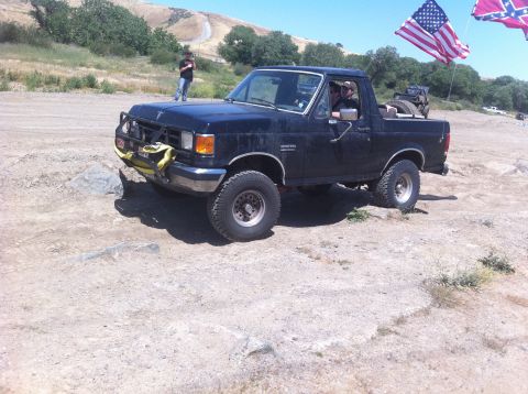1990 Ford Bronco - This 1990 Ford Bronco is shown off-roading, flying American and Confederate flags from its rear.