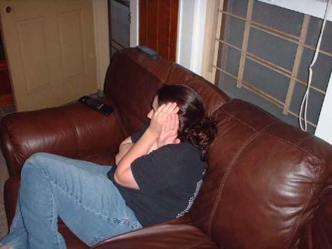 1996 Ford Taurus - A person sits on a leather couch, covering their face with their hands.
