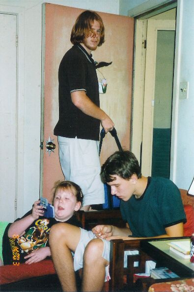1996 Ford Taurus - A group of three people are gathered in a room, with the youngest holding a small blue item.