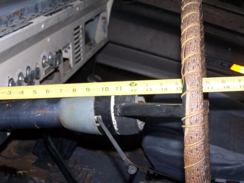 1973 Ford Bronco - A tape measure is placed against the steering column of a vehicle's interior.