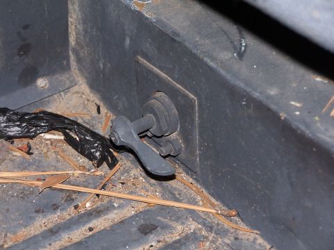1973 Ford Bronco - Close-up of an interior latch mechanism, partially obscured by debris.