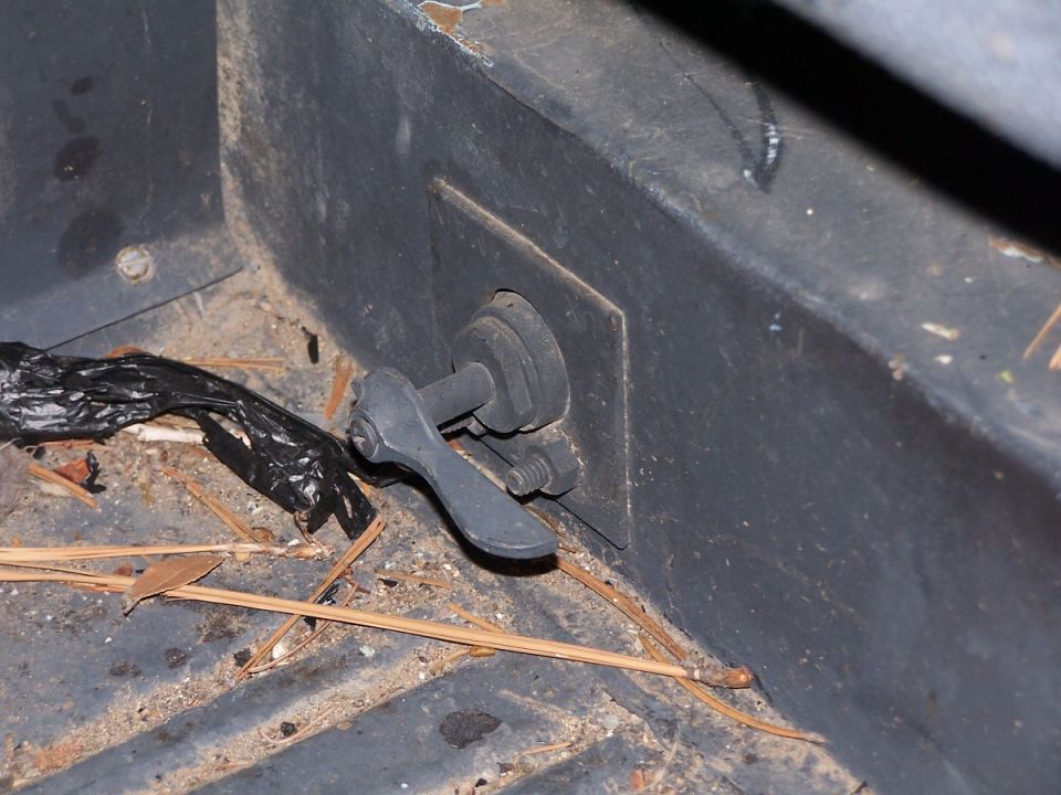 Interior latch mechanism with black plastic debris and pine needles
