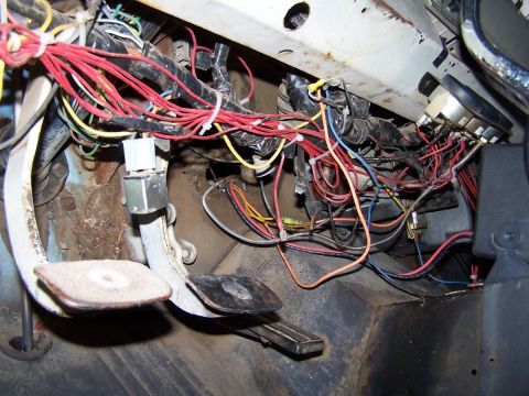 1973 Ford Bronco - A complex tangle of wires and the brake and accelerator pedals are visible in this interior shot.