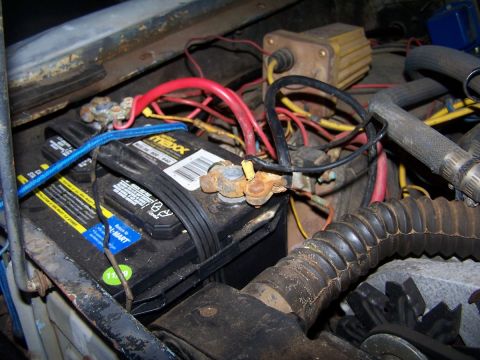 1973 Ford Bronco - Close-up view of a vehicle's engine bay, focusing on the battery and wiring.