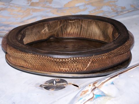 1973 Ford Bronco - An air cleaner assembly with a mesh filter and rubber seal is shown.